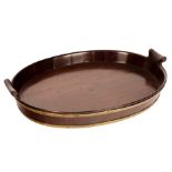 A George III mahogany brass bound oval tray, with two brass bands and shaped lug handles,
