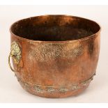 A copper cauldron with lion mask handles,