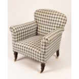 A 20th Century upholstered armchair on tapered turned legs with casters,