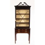 An Edwardian mahogany cabinet with pierced swan neck cornice and dentil fret carving,