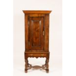 An early 19th Century oak cupboard on a single drawer stand,