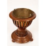 An Edwardian waisted slatted jardinière stand on ball feet,