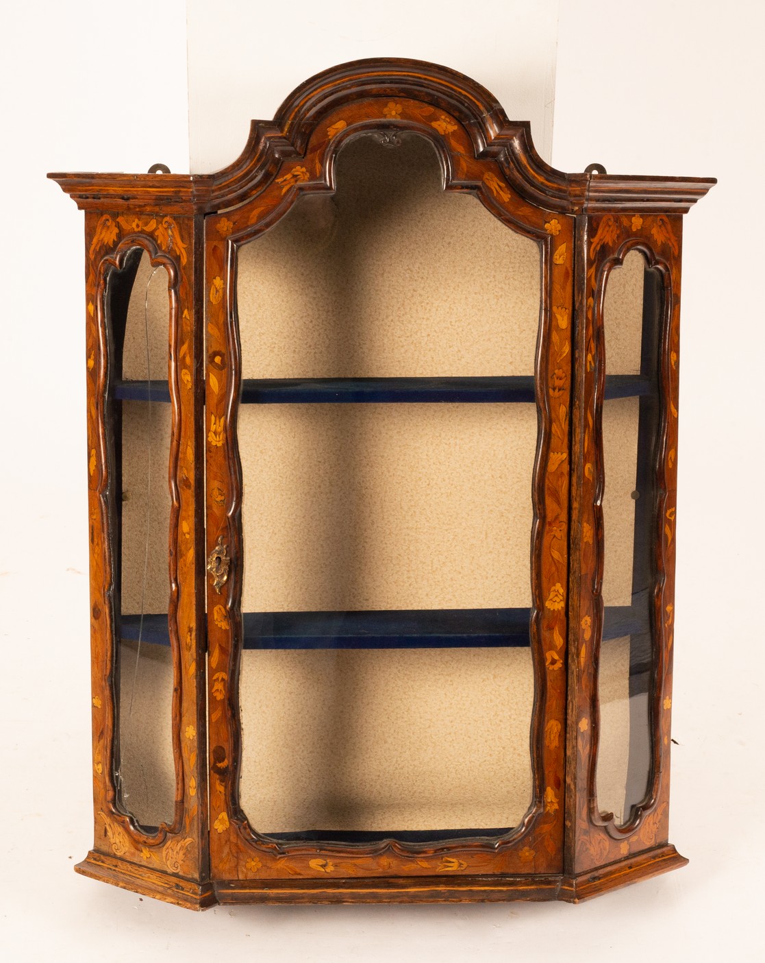 A Dutch floral marquetry display cabinet, with shaped cornice above a glazed door with canted sides,