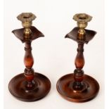 A pair of turned wood candlesticks,