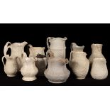 Eleven saltware jugs, various patterns, one pewter lid,