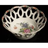 A Worcester circular basket painted to the interior well with a spray of flowers,