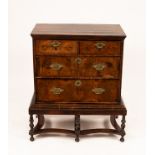 A George I walnut chest of two long and two short drawers on a later stand,