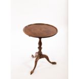 A mahogany tripod table with a dished circular top,
