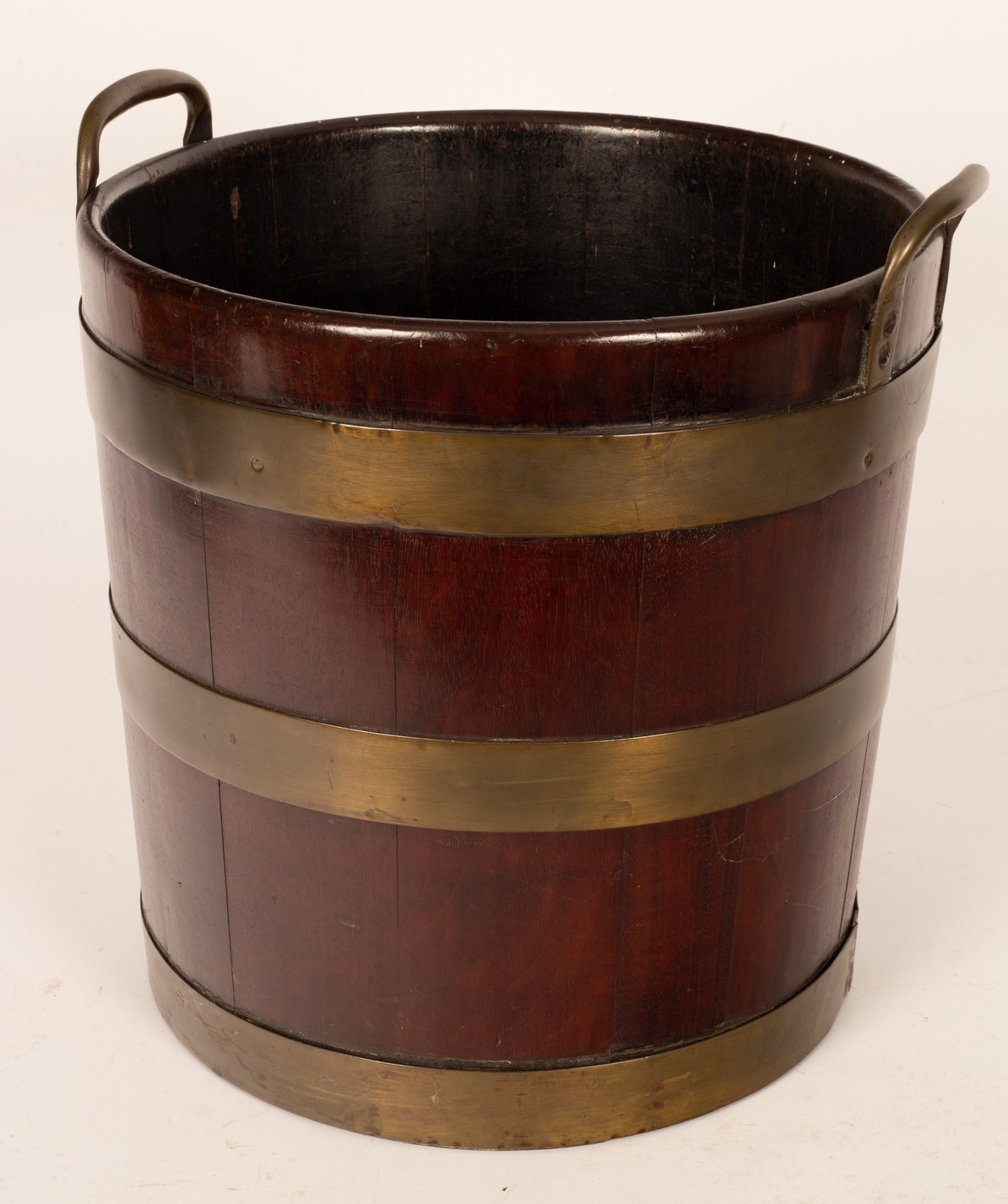 A George III mahogany brass bound peat bucket, with loop handles and three brass bands,