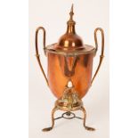 A twin handled copper and brass urn with central finial, beaded and embossed detail to tripod base,