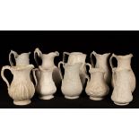 Ten saltware jugs, most with floral decoration,