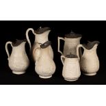 Six saltware jugs, floral decoration, pewter lids,