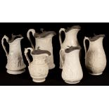 Six saltware jugs, various patterns, pewter lids, the largest 24.