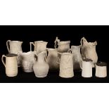 Twelve saltware jugs, various patterns, three with pewter lids,