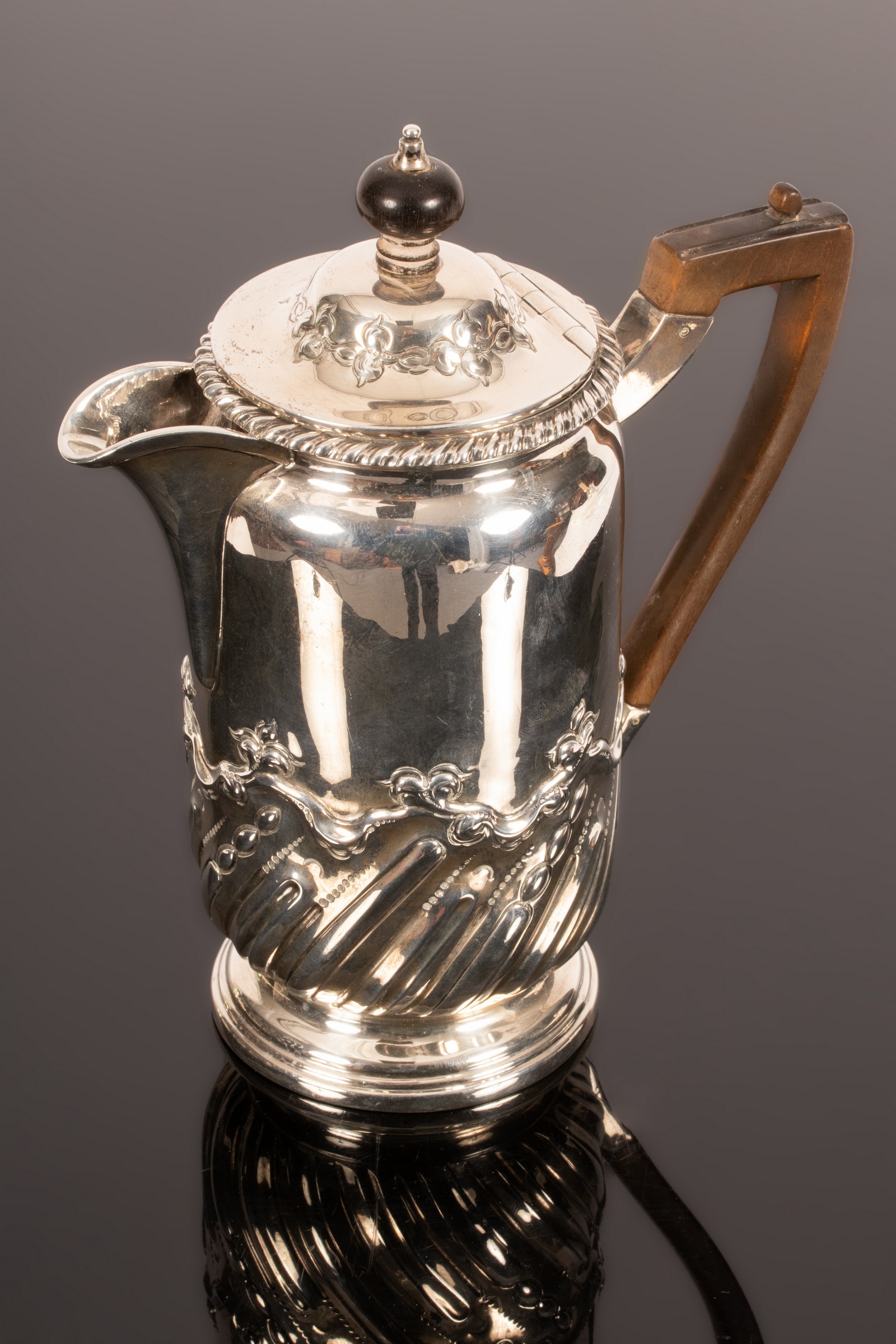 A late Victorian silver hot water jug, London 1900, with wooden handle, 20.