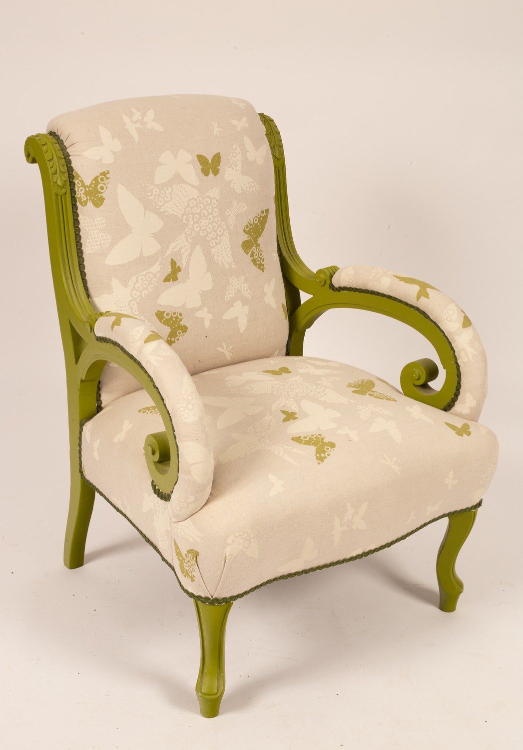 A modern painted and upholstered armchair, scrolled arms,
