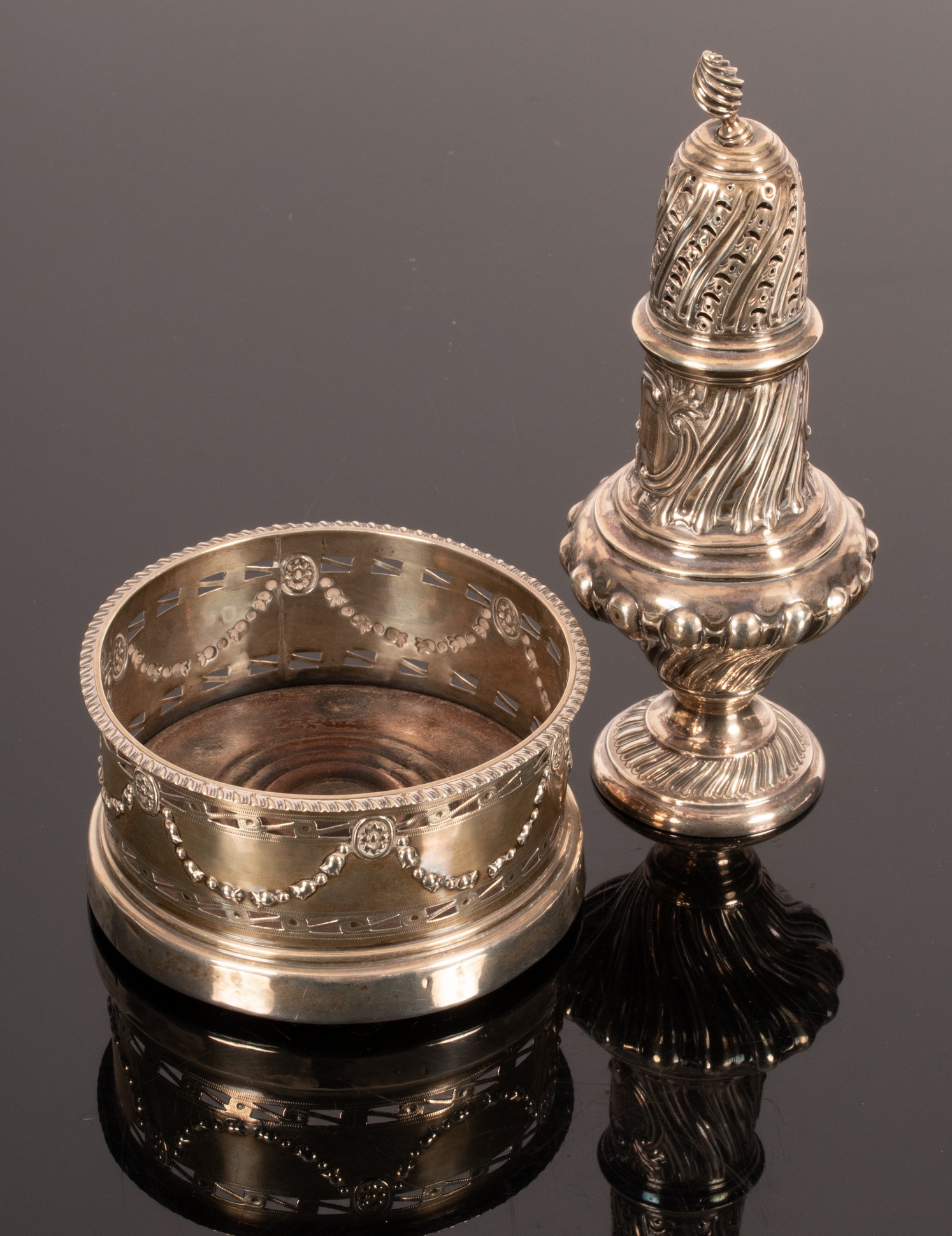 An Edwardian silver wine coaster, Nathan & Hayes, Chester 1905 and a sugar caster dated 1884-1909,