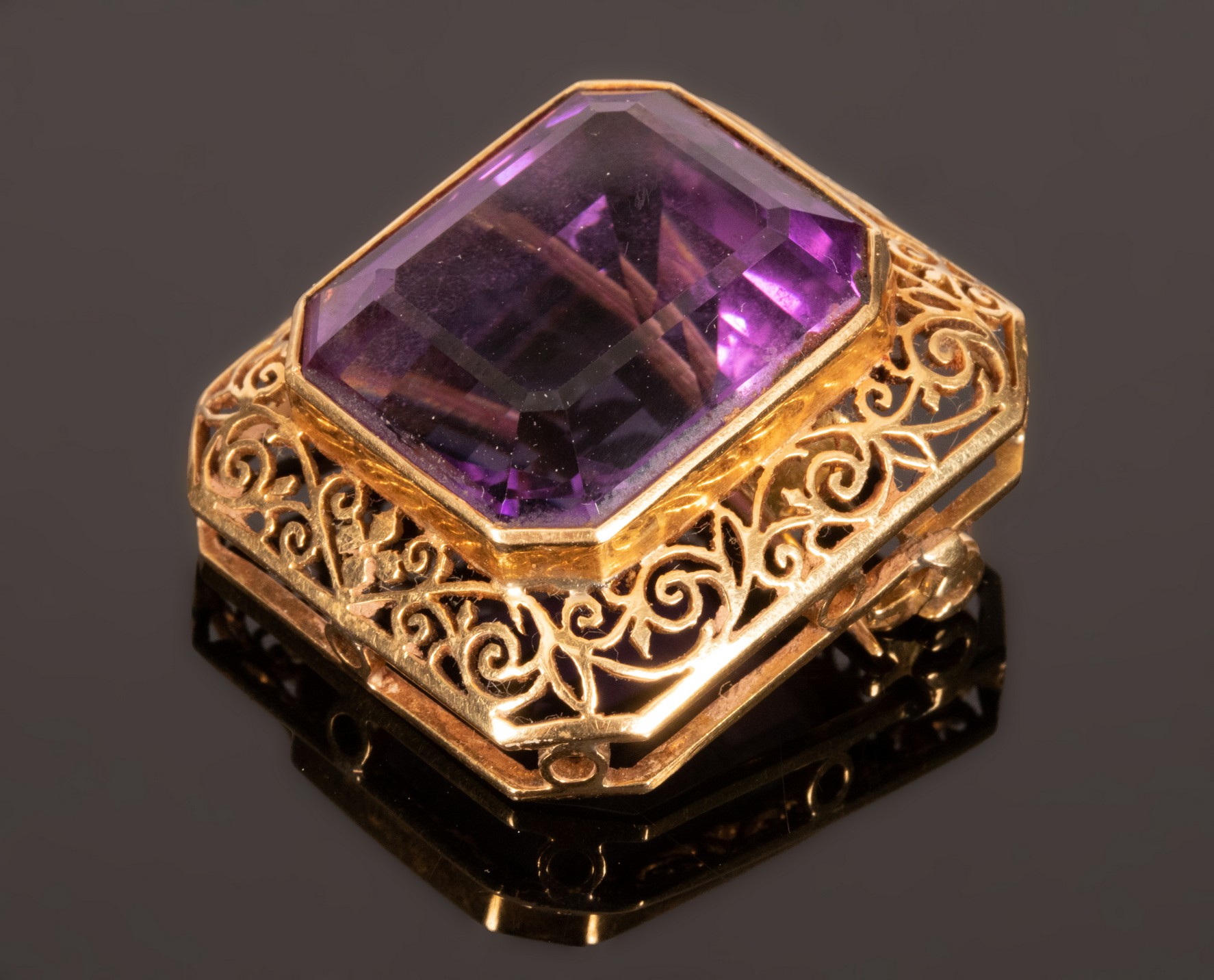 An amethyst pendant brooch, set in 18k yellow gold, the emerald cut stone 19.3mm x 16.5mm x 12.