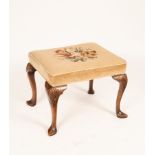 A walnut stool with upholstered floral needlework seat, on cabriole legs with pointed feet,