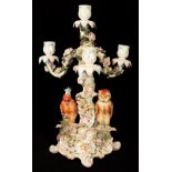 A German porcelain flower encrusted four-light candelabrum, modelled with an owl and parrot,