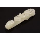 A Chinese white jade carved belt hook, Qing, in the form of a dragon,