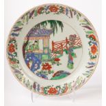 A Chinese famille vert plate, Kangxi, decorated with figures inside and outside in the garden,