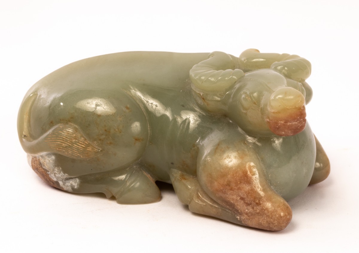 A Chinese celadon jade recumbent buffalo, 19th/20th Century,