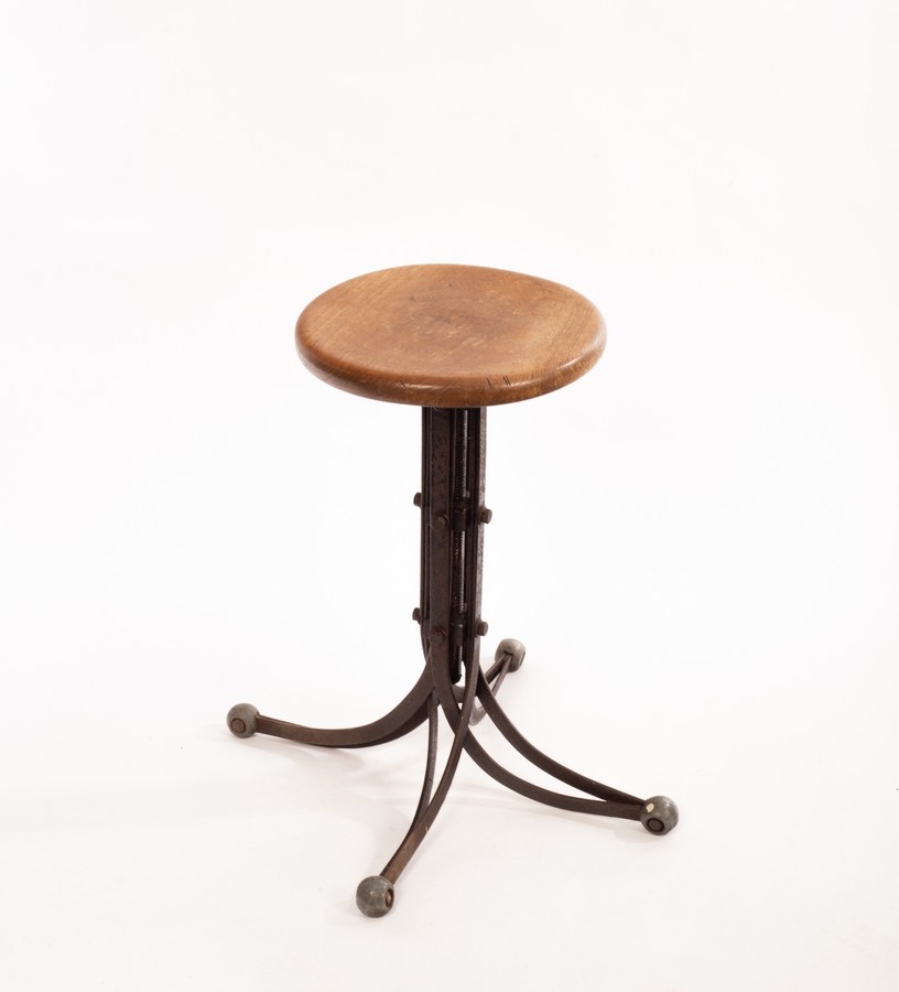 Rubery Owens, a blade stool, circa 1950s, the ash seat on adjustable aluminium support on ball feet,