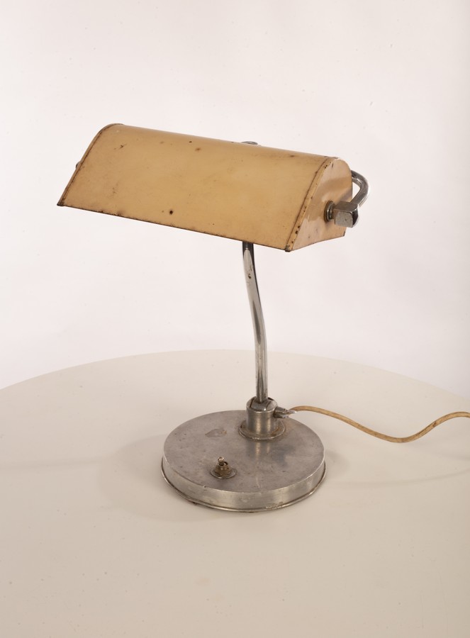 A metal desk lamp, the adjustable shade on stainless steel arm on an aluminium clad plinth base,