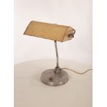 A metal desk lamp, the adjustable shade on stainless steel arm on an aluminium clad plinth base,