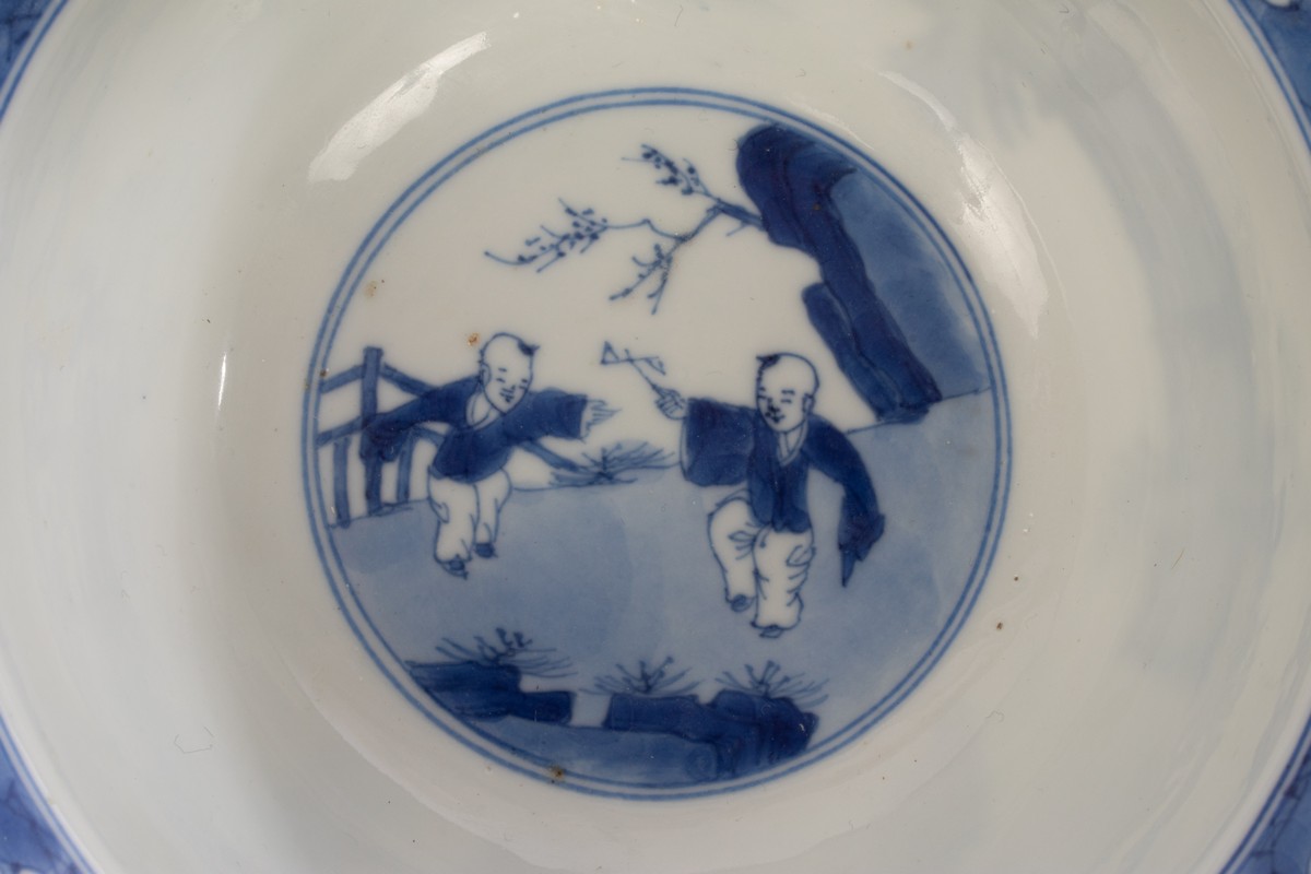 A Chinese blue and white porcelain bowl, Kangxi, depicting ladies and a boy playing in the garden, - Image 4 of 10