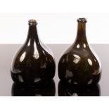 Two late 18th Century dark-olive-green glass wine bottles of flattened form,