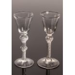 Two 18th Century air twist drinking glasses with rounded funnel bowls, one with a shoulder knop,