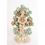 A Bow figure of a cherub with flower basket before bocage and a smaller pair of cherubs with