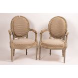 A pair of 18th Century style French armchairs with upholstered seats and oval padded backs,