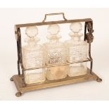 A plated Tantalus fitted three cut glass decanters with stoppers, the frame,