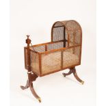 A Regency mahogany framed cradle on stand, the cradle with caned hood and sides,