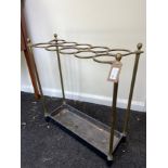 A brass umbrella stand, the top with ten circular divisions with cast iron drip tray beneath,