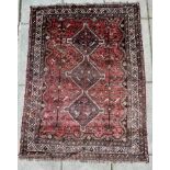A Shiraz carpet, South West Persia, the strawberry red field centred by a stepped ivory medallion,