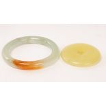 A Chinese yellow jade carved disc, 20th Century, Yubi, and a jade bangle,
