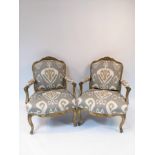 A pair of 18th Century giltwood armchairs with upholstered seats and backs,