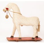 A fabric covered toy horse on a stand,