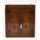 An oak wall hanging cupboard, 17th Century and later adapted,