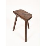 A Victorian primitive oak stool on three legs, 40cm wide, 22cm deep, 48.