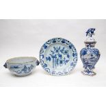 A Dutch Delft blue and white charger, a vase and cover and a bowl with animal mask handles,