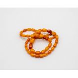 A Baltic amber necklace of graduated oval beads, approximately 28.