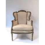 A late 19th Century giltwood wingback fauteuil with upholstered seat and back,