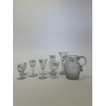 An Anglo-Irish cut glass water jug with diamond engraving, and eight drinking glasses,
