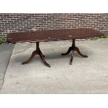 A mahogany veneered twin pedestal dining table,