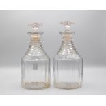 A pair of decanters and stoppers with step-cut necks and panelled sides,
